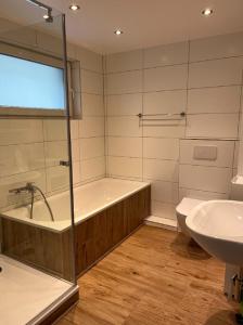 ein Badezimmer mit Badewanne, Toilette und Waschbecken in der Unterkunft Haus Sonnenschein in Wunstorf