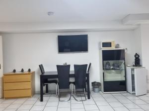 a dining room with a black table and chairs at Schicke Gästewohnung Düsseldorf Neuss Köln in Neuss