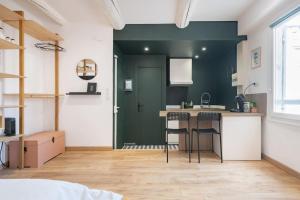 une cuisine avec un comptoir et des tabourets dans une pièce dans l'établissement Le Cocon de Grignan, à Marseille