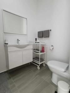 une salle de bain blanche avec un lavabo et des toilettes dans l'établissement Turtle Bay Village garden 2-bedroom sea apartment, à Kyrenia