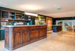un bar con barra de madera en una habitación en B&B HOME Paris Mairie de Saint-Ouen, en Saint-Ouen
