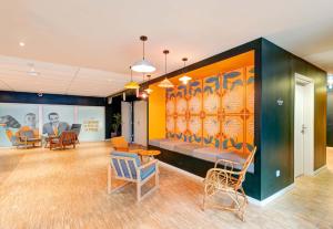 a lobby with a couch and chairs and a table at B&B HOME Paris Mairie de Saint-Ouen in Saint-Ouen