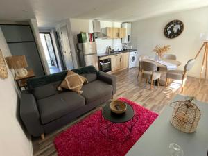 a living room and kitchen with a couch and a table at A louer appartement t2 in Espalion