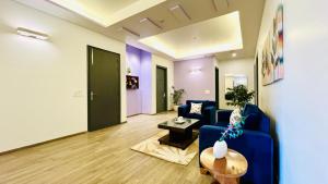 een woonkamer met een blauwe bank en een tafel bij BluO Medicity - Boutique Hotel Gurgaon in Gurgaon