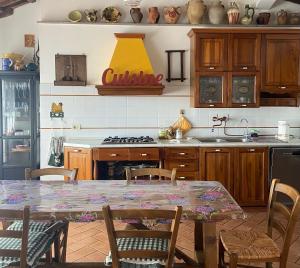una cucina con tavolo e piano cottura forno superiore di Tuscany Location a Marta