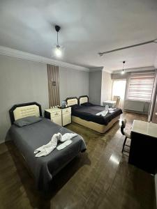 sypialnia z 2 łóżkami, stołem i biurkiem w obiekcie NIGRUM HOTEL w mieście Nevşehir