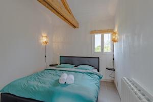 ein Schlafzimmer mit einem Bett mit zwei weißen Schuhen darauf in der Unterkunft Gîte Bellevue in Paulin