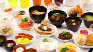 Dormy Inn Premium Nagoya Sakae في ناغويا: طاولة مليئة بالأطباق بأنواع مختلفة من الطعام