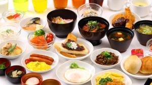 名古屋多美迎PREMIUM名古屋荣酒店的桌子上摆满了各种食物的碗
