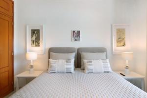 una camera da letto con un letto bianco con due lampade di Ap np ad Armação de Pêra Altre 17 foto