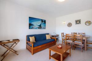 un soggiorno con un divano blu e un tavolo di Ap np ad Armação de Pêra