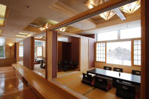 Hotel Morinokaze Tateyama‎ في توياما: غرفة كبيرة فيها طاولة وكراسي