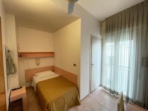 - une petite chambre avec un lit et une fenêtre dans l'établissement Hotel Plaza, à Rimini