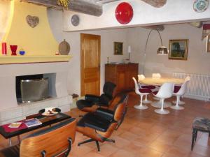 a living room with a table and chairs and a fireplace at Le Mas Saint Jacques in Crillon-le-Brave