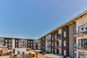 una fila de edificios de apartamentos con balcones y mesas en WINK Aparthotel Quiver Tree, en Stellenbosch