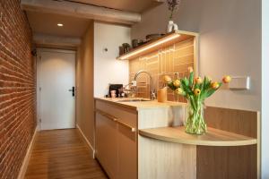a kitchen with a vase of flowers on a counter at Storehouse Studios in Amsterdam