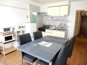 uma cozinha com uma mesa de vidro e cadeiras em Ueda Building - Vacation STAY 8565 em Asahikawa