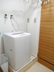 uma casa de banho branca com um chuveiro e um WC. em Ueda Building - Vacation STAY 8565 em Asahikawa