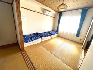 una piccola camera con due letti e una finestra di Ueda Building - Vacation STAY 8561 a Asahikawa