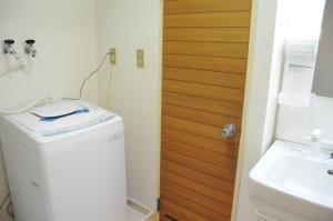 bagno con lavatrice e porta in legno di Ueda Building - Vacation STAY 8561 a Asahikawa