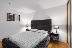 Schlafzimmer mit einem großen Bett mit einem schwarzen Kopfteil in der Unterkunft Parkway House in Chelmsford