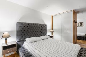 a bedroom with a large bed with a gray headboard at Chelmsford Town Centre, Modern 1 Bed Apartment in Chelmsford