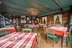 un ristorante con tavoli e sedie con tovaglie rosse e bianche di Gostilna Pri Martinu a Kranjska Gora