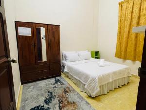 1 dormitorio con 2 camas y armario en Kota Bharu Homestay, en Kota Bharu