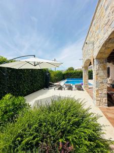 a patio with an umbrella and a pool at Villa Seaside in Krk