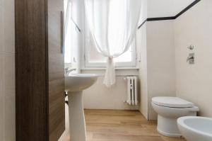 een badkamer met een wastafel en een toilet en een raam bij Blue Room in Milaan +15 foto's