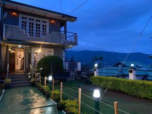 a house with lights on the side of it at New Royal Mount Hotel in Nuwara Eliya