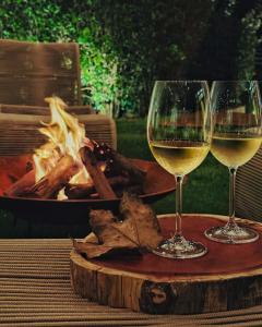 due bicchieri di vino bianco su un tavolo con un fuoco di Villa Boréal Hostellerie ad Águas de Lindóia