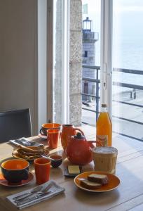 a table with plates of food and a bottle of juice at Chambres Breizh Café in Cancale +19 photos