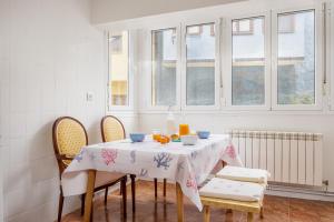 una mesa de comedor con sillas y naranjas. en Appto El Cantábrico en Ribadesella, en Ribadesella