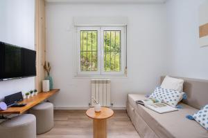 una sala de estar con un sofá y una mesa en Appto El Cantábrico en Ribadesella, en Ribadesella