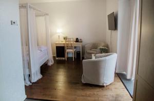una sala de estar con mesa y sillas y una habitación con escritorio en Hotel Bella Luna, en Båstad