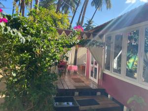 een huis met een veranda en een boom bij Art village resort Goa in Canacona