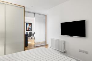 a white room with a tv on a wall at Chelmsford Town Centre, Modern 1 Bed Apartment in Chelmsford +14 photos
