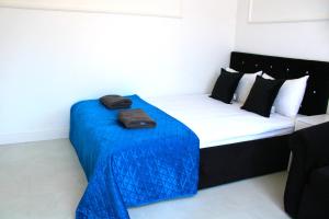 una camera con un letto con una coperta blu sopra di Willa Piryt z WIDOKIEM NA LAS a Krynica Morska