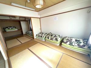 een lege kamer met vier kussens op de vloer bij Ueda Building - Vacation STAY 8558 in Asahikawa