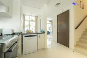 a kitchen with a stove and a sink and a door at AWS Homes - Elegant Villa with BBQ Area & Garden in Dubai