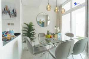 a dining room with a glass table and chairs at AWS Homes - Elegant Villa with BBQ Area & Garden in Dubai
