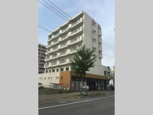 een hoog wit gebouw aan de kant van een straat bij Ueda Building - Vacation STAY 8558 in Asahikawa