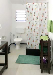 een badkamer met een toilet en een douchegordijn bij Art village resort Goa in Canacona