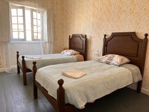 1 dormitorio con 2 camas y ventana en Fernando Guest House, en Aveiro