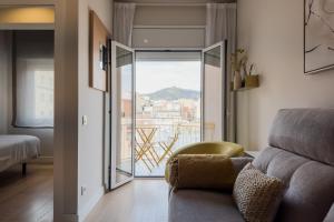 a living room with a couch and a large window at Barcelona Amelie Apartment in Hospitalet de Llobregat
