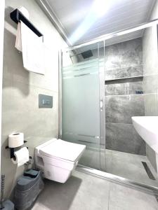 y baño con ducha, aseo y lavamanos. en Angel Beach Hotel Kızkalesi Mersin, en Erdemli