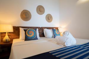 1 dormitorio con 1 cama con sábanas y almohadas blancas en Pili Pili Boho, en Jambiani