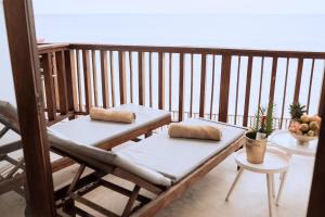a balcony with two cushions on a wooden bench at Pili Pili Boho in Jambiani