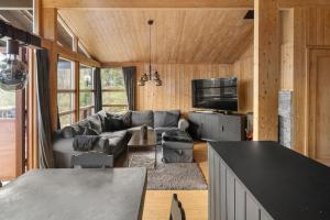 a living room with a couch and a tv at Koselig fjellhytte i Trysil Ski & Turmuligheter in Trysil